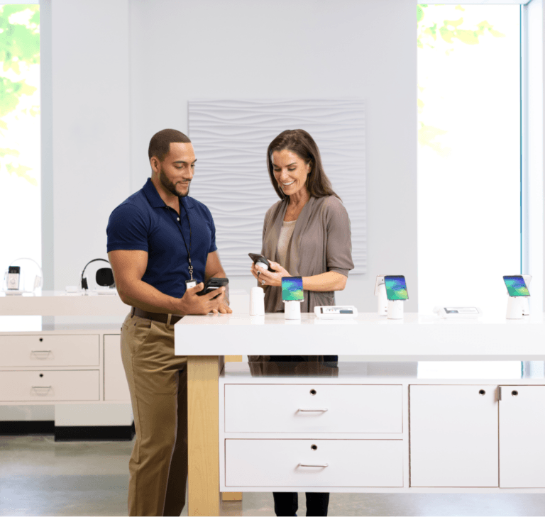 소매점에서 모바일 기기를 보고 있는 남성과 여성