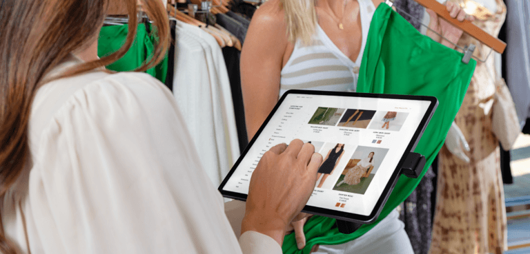 NE150 스탠드에서 의류 옵션을 살펴보는 두 여성