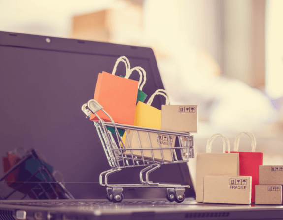 노트북 위에 놓인 작은 쇼핑 카트